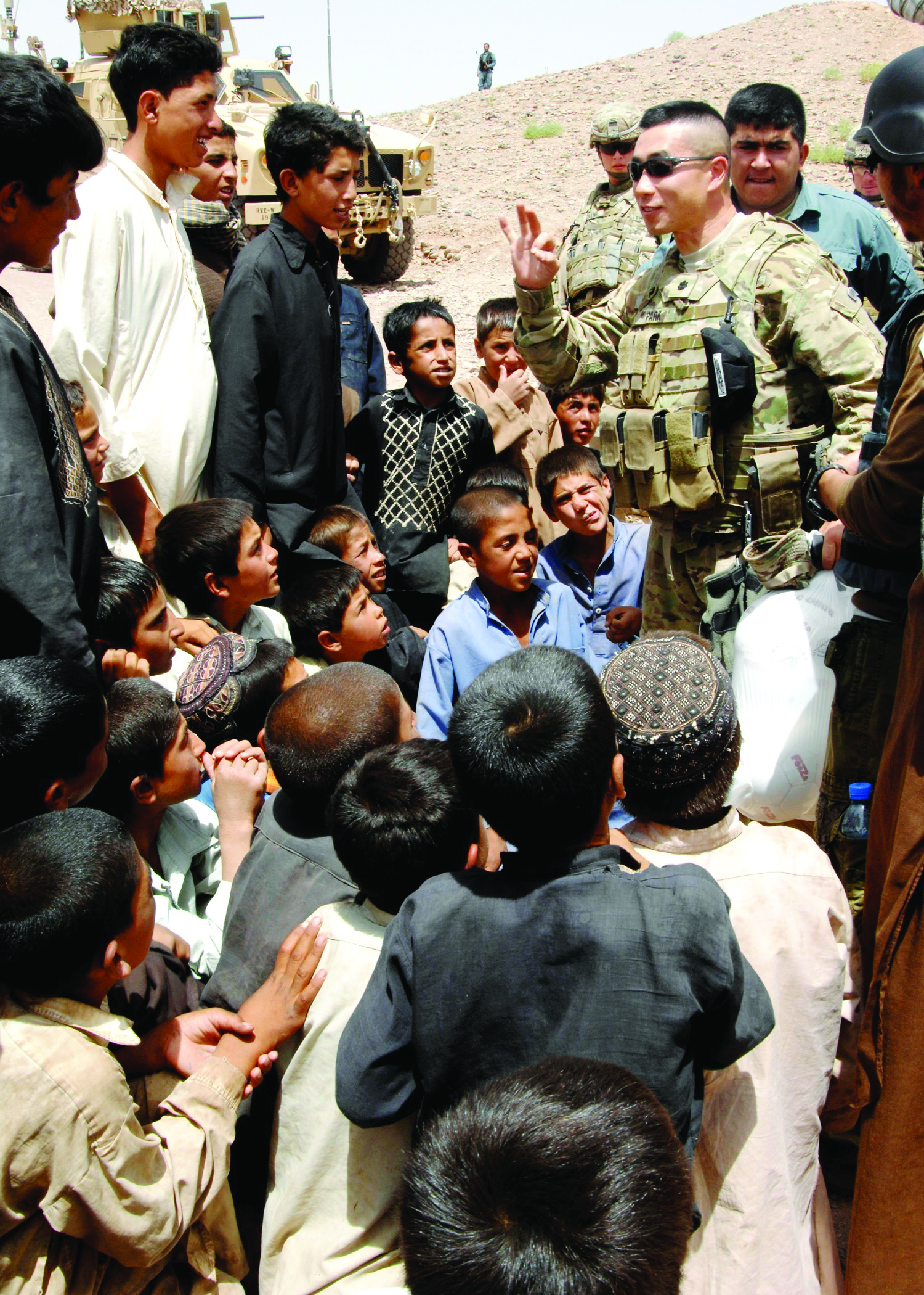 Image of a soldier engaged in conversation with a group of Afghanistan locals.